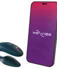 We-vibe Sync 2 Velvet Green bredvid en smartphone som visar loggan till appen. Vit bakgrund.