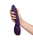 Hand håller i We-Vibe Wand 2 Purple, kraftfull magic wand vibrator med ergonomisk design.