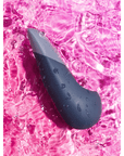 Stämningsbild på Womanizer Vibe Dark Blue Klitorisvibrator i rosa vatten.