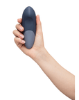 Hand som håller i Womanizer Vibe Dark Blue Klitorisvibrator framsida.