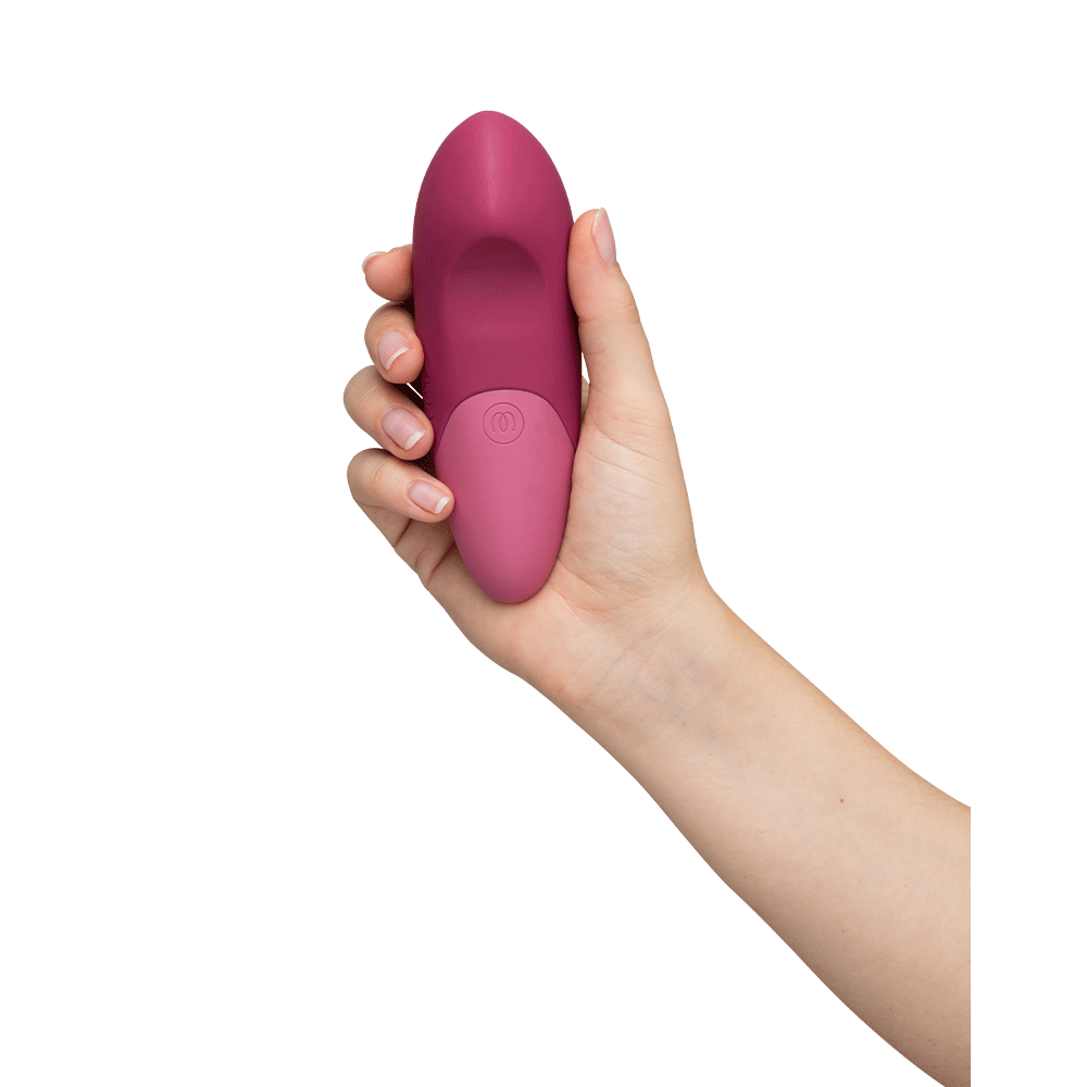 Hand som håller i Womanizer Vibe Dusky Pink Klitorisvibrator så att undersidan syns.