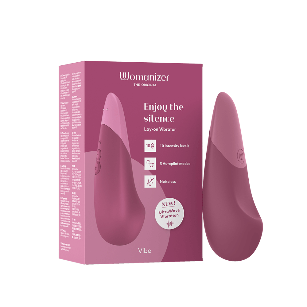 Womanizer Vibe Dusky Pink Klitorisvibrator bredvid förpackning.